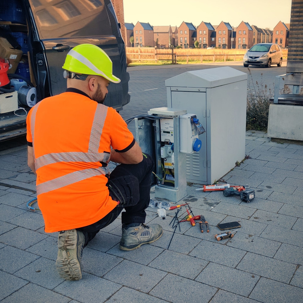 The electrician setting up the community power plug on Darwin Green's Plaza