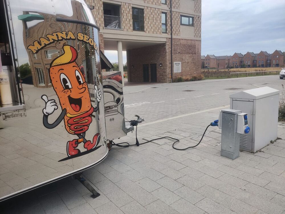 The rear of a food truck plugged into the power socket on Darwin Green's Plaza